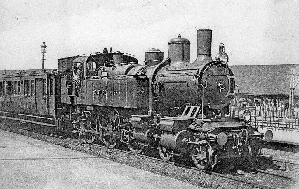 Gros plan sur la locomotive n°57 de la Ceinture, en tête d'un train circulaire stationnant à Belleville-Villette
