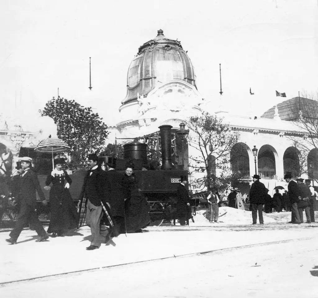 Une locomotive à vapeur trône au milieu des premiers visiteurs de l'Exposition